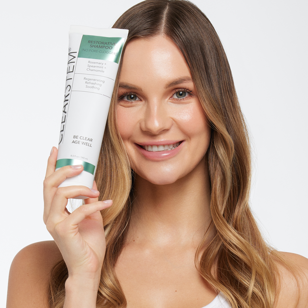 Girl holding CLEARSTEM's non-comedogenic shampoo, 