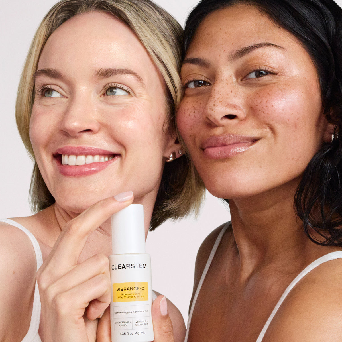 Two women smiling, one holding a CLEARSTEM serum