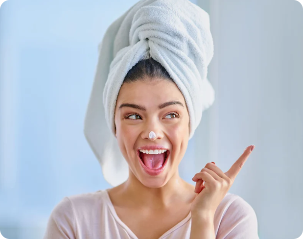 a happy woman pointing up with a towel on her head - Clearstem skincare  learning center