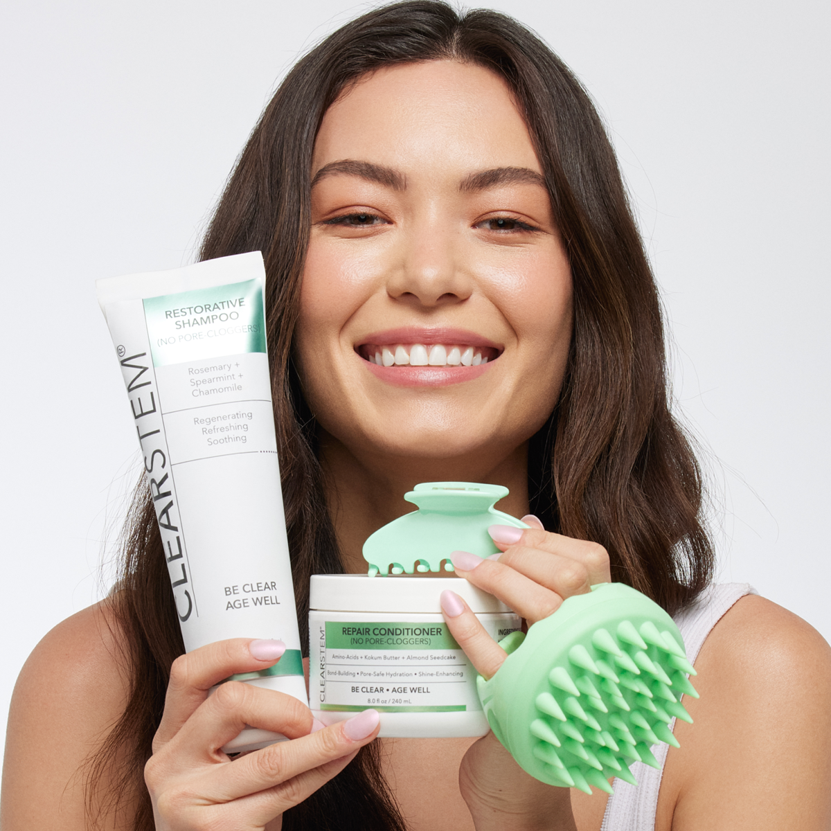 Person holding CLEARSTEM acne-safe shampoo and conditioner